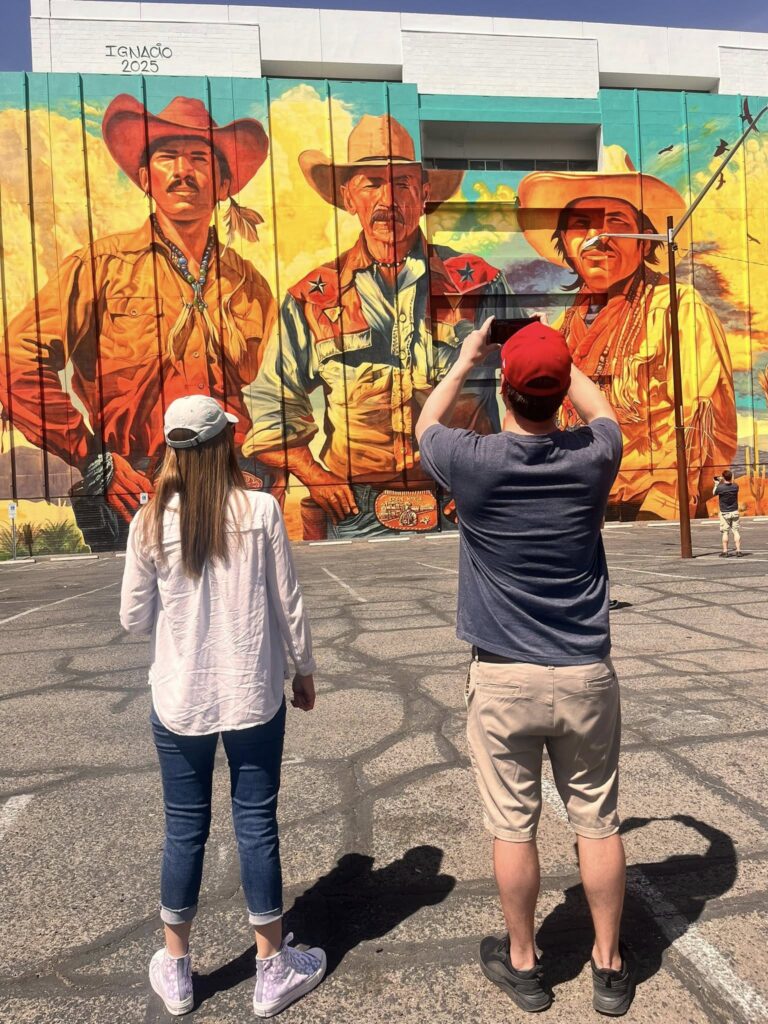 Tour Guests Visit Los Vaqueros Mural by Ignacio Garcia