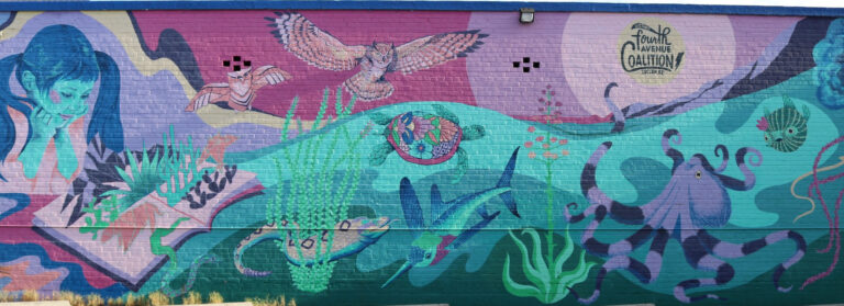 Colorful Fourth Avenue mural with wildlife, desert plants, and aquatic imagery in Tucson.