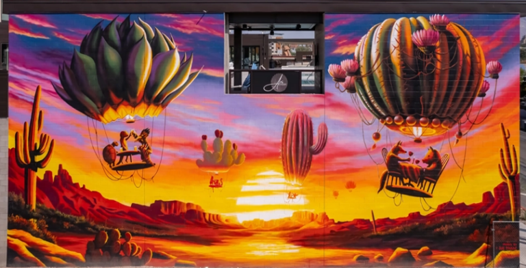 Colorful desert sunset mural with cactus hot air balloons on the Downtown East mural route in Tucson.